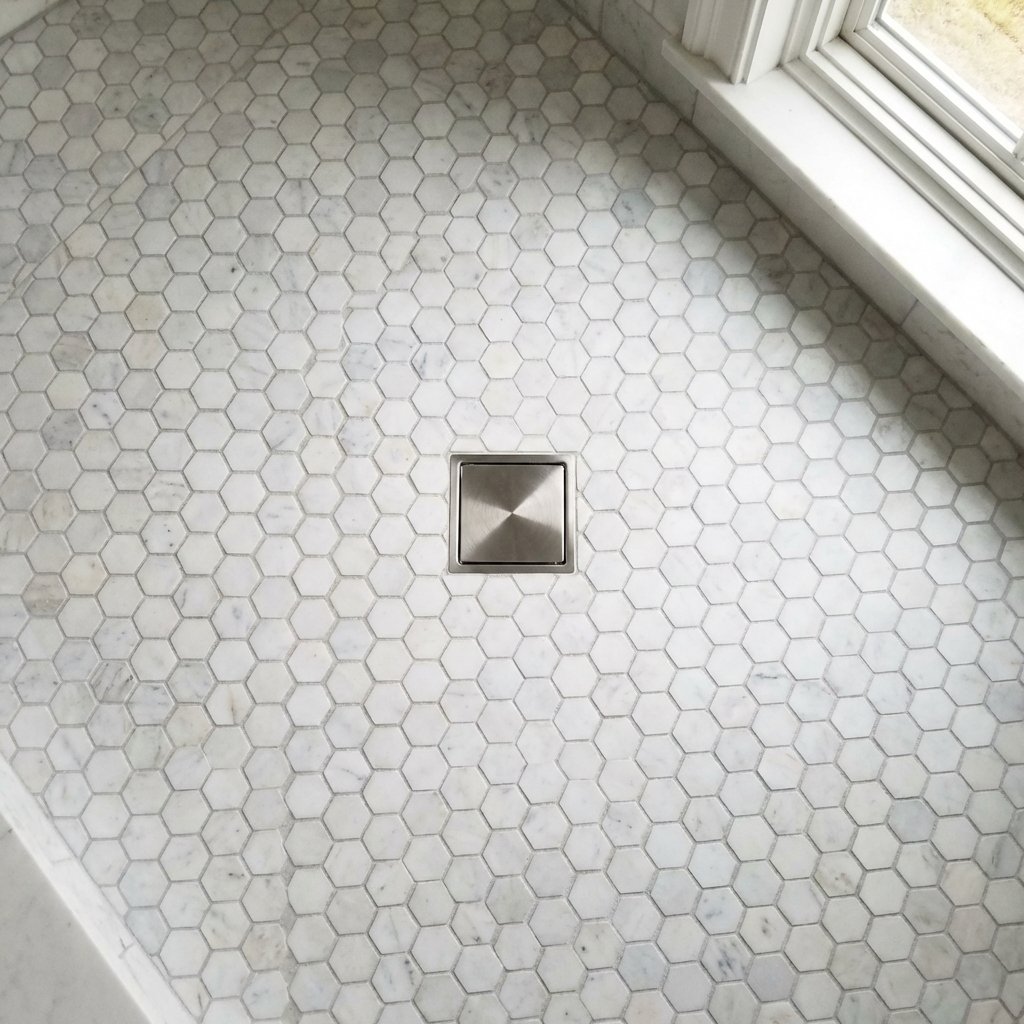 Mosaic shower floor tile inspiration in Newton — hexagon carrara marble